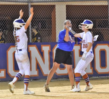 Harmony Coach Kristi Mindrup congratulates seniors Ireland Sibbett (right) and Amanda Whalen after a big hit in a game earlier this season. The two were part of a senior class that brought the Longhorns their first district title since 2014. PHOTO/KATIE WILLIAMS