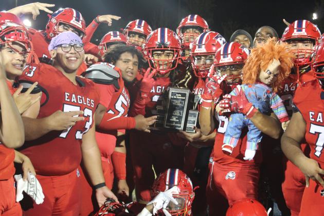 Poinciana players pose with the Battle of the Boulevard trophy after Friday's 35-8 victory. PHOTO/KEN JACKSON