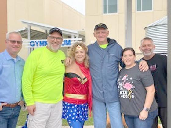 A number of volunteers, including Wonder Woman — her invisible jet couldn’t fly Saturday because of weather — distributed presents at A Hero For Kids’ Christmas for the Kids distribution Saturday at Canoe Creek K-8. PHOTO/DAVID CHIVERS