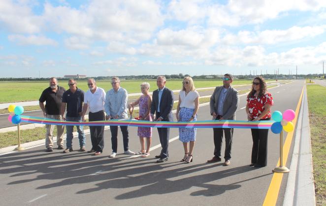 Standing right on the road, Osceola County leaders cut the ribbon on Neovation Way, which will connect Neptune Road directly to NeoCity. PHOTO/KEN JACKSON