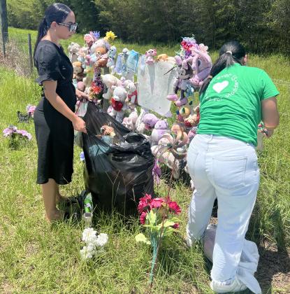 Volunteers take down a memorial to Madeline Soto along Hickory Tree Road on Thursday. The fence is on private property and the owners called for its removal. SUBMITTED PHOTO