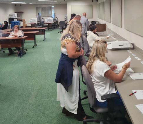 Osceola Supervisor of Elections officials hand-studied ballots Friday that count machines returned as overvoted or undervoted as part of the recount in the Kissimmee mayor primary election. PHOTO/KEN JACKSON