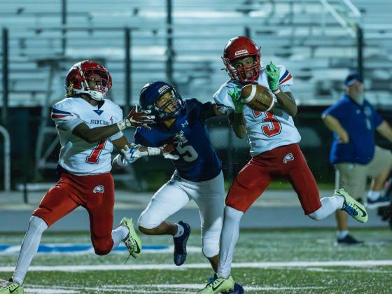 Poinciana's Ernest Nunn (3) tries to haul in a pass as Celebration's Sean Nuzzi tries to defend him and Jaeden Gerard (7). PHOTO/MARIO CASAMALHUAPA