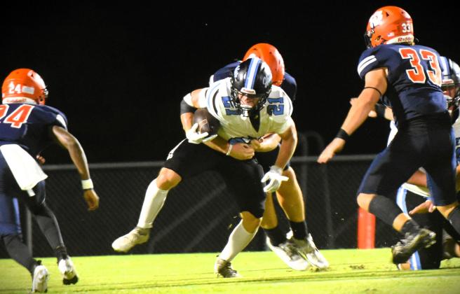 Tohopekaliga spent Friday chasing Hagerty running backs. Porter Williams carries Friday as Tohopekaliga's Nathan Freeze (24) and Ryan Wells (33) move in to make a tackle. PHOTO/KATIE WILLIAMS