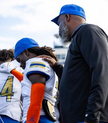 Osceola assistant coach and former Kowboy Chad Mascoe consoles Jakyri Watson following Friday's 26-7 loss to West Boca Raton in the Class 6A championship game. PHOTO/TAYLOR MCFEE