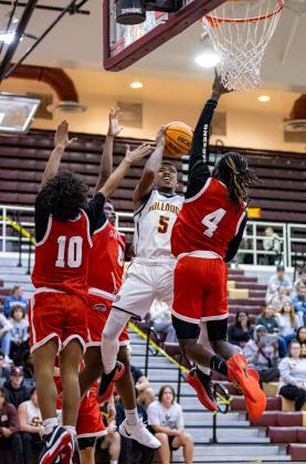 St. Cloud's Alex Springs puts up a shot against the Gateway defense of Isaiah Mcgill (0), Ashaun Julian (4) and Jeremias Guadalupe (10) in Wednesday's semifinal at Coach Mac Gym. PHOTO/TAYLOR MCFEE