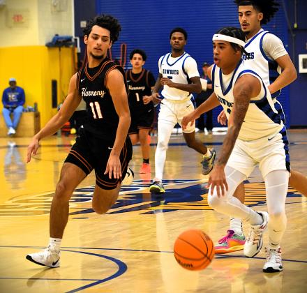 Harmony's Ivan Ramos tries to slow down Osceola's Jordan Isaac on his way to the lane in Wednesday's OBC tournament semifinal. PHOTO/KATIE WILLIAMS