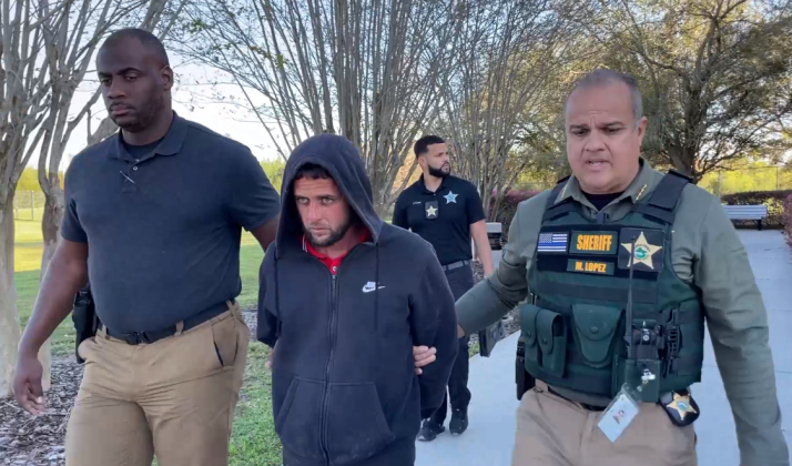 Osceola County Sheriff Marcos Lopez leads Julio Ramos-Aleman to a cruiser Friday to be booked into the Osceola County Jail, after police say he stabbed his wife multiple times early that morning.. PHOTO/OSCEOLA COUNTY SHERIFF'S OFFICE