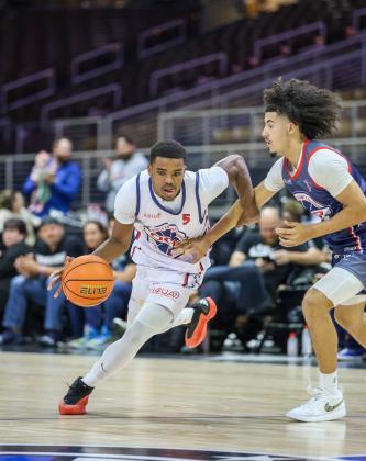 St. Cloud's Alex Springs (White 5) drives the ball on Osceola's Luke McCrimon (Blue 1) in the Osceola County Premier event at the Silver Spurs Arena. PHOTO/TAYLOR MCFEE