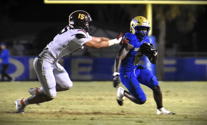 Osceola's Jeff Sinophat, who caught a 30-yard touchdown pass to give the Kowboys the lead for good, looks to gain ground against St. Cloud defender Jude Cockcroft. (Photo/Katie Williams)