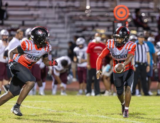 Gateway quarterback Aristotle Span Jr. (10), shown handing off to Nydrell Thigpen in a win over Cypress Creek earlier in the year, passed for three touchdowns in a regular season-ending 33-15 win over Celebration Thursday. (Photo/Taylor McFee)