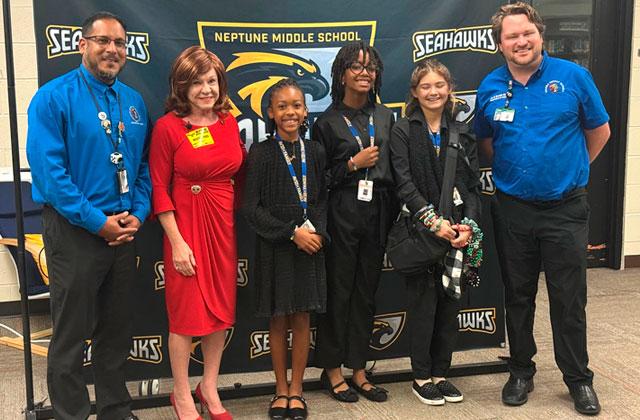 Osceola School District Director of Middle School Curriculum Henry Santiago, Rep. Paula Stark and Education Specialist for Social Studies Cory Puppa pose with the winning team of Carly Lech, Lucy Graham and Elysmar Francois at Friday’s “Build-A-Bill” competition. (Photo/David Chivers)
