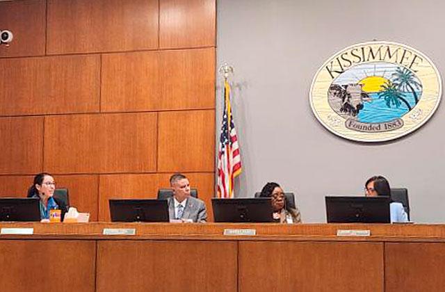 Kissimmee City Attorney Olga Sanchez de Fuentes (far left) and Mayor Jackie Espinosa (far right) discuss the reasoning behind the mayor's motion to terminate the attorney prior to the vote at Monday's Commission meeting. (Photo/Ken Jackson)