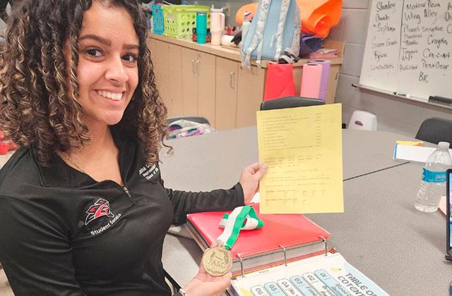 GHS Student Senate Student Body Representative Alaina Candelario shows off the gold medal and the binder of Student Senate’s accomplishments responsible for it, and the judge’s score sheet. (Photo/Ken Jackson)