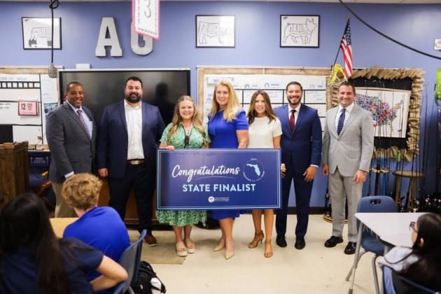 From left, Senior Chancellor Paul Burns, Harmony Middle School Thomas Dunham, Harmony Middle agriculture teacher Kyndall Brown, Osceola County School Board Vice Chair Paula Bronson, School Board Chair Heather Kahoun, Florida Commissioner of Education Anastasios Kamoutsas and School District of Osceola County Superintendent Dr. Mark Shanoff at the announcement Monday that Brown is a 2027 Florida Teacher of the Year finalist. (Photo/Florida Department of Education)