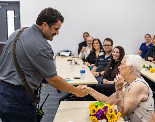 Donna Allred shares a moment with St. Cloud Fire Rescue Lt. Angel Rodriguez at Friday’s ceremony. (Photo/Taylor McFee)