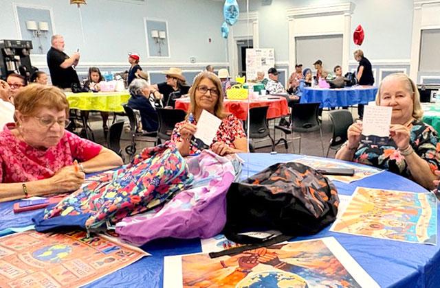 Osceola Council on Aging seniors offer words of wisdom and encouragement to local students for the upcoming school year. The notes and school supplies will fill backpacks that Northbridge University will give out at their Back-to-School Event on August 1. (Photo/Debbie Daniel)