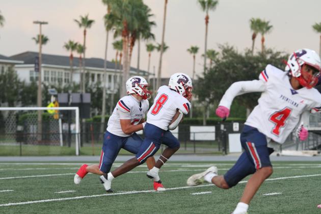 Jamare Eugene, shown here taking a handoff from quarterback Lucas Minenok in the Aug. 21 game at Celebration, scored on a third-quarter touchdown run Friday at Harmony that gave the Eagles a lead it'd never lose Friday against Harmony. (Photo/Michelle Kostuch)