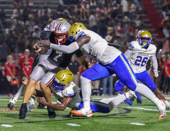 Osceola defensive linemen Jason Lewis (top) and Dory Thimote (bottom) wrap up Lake Mary quarterback Remy Jarman for one of the Kowboys' five sacks in OHS' 17-9 win over the Rams Friday.  (Photo/Taylor McFee)