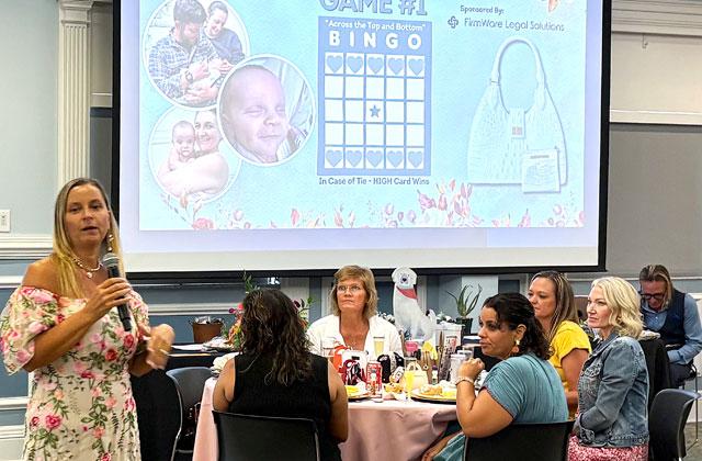 United In Love Adoptions founder and Agency Attorney Barbara “BJ” Harris kicks off the first Bingo game Saturday for a designer purse prize. (Photo/Terry Lloyd)