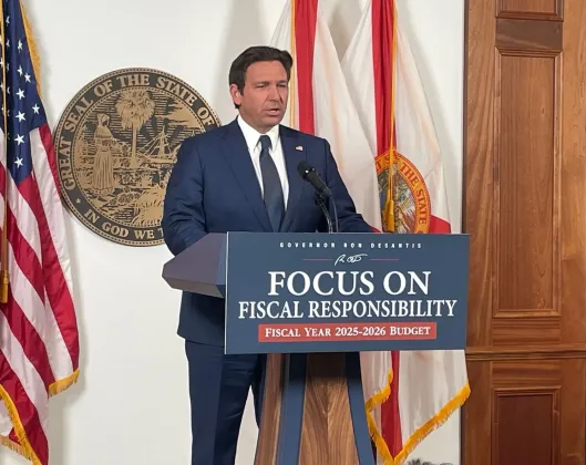 Gov. Ron DeSantis, shown releasing his proposed budget, wants a state “DOGE” to look for waste in government. (News Service of Florida Photo/Tom Urban)