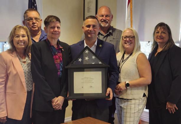 U.S. Rep. Darren Soto presented a U.S. flag that flew over the U.S. Capitol on May 1 in honor of Adelene Bay to her daughter Judy (front, second from left). It will be displayed in the County Commission chambers. PHOTO/KEN JACKSON