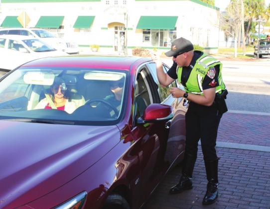 A Kissimmee Police Officer pulls over a driver to inform him that he did not stop for a plain-clothed officer in a crosswalk. NEWS-GAZETTE PHOTO /BRIAN MCBRIDE
