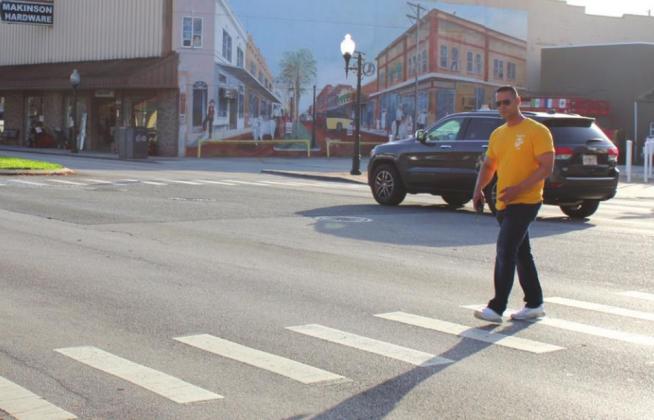 Kissimmee Police Lt. Omar Berrio in plan clothes crosses Broadway during a pedestrian-safety operation. NEWS-GAZETTE PHOTO/BRIAN MCBRIDE