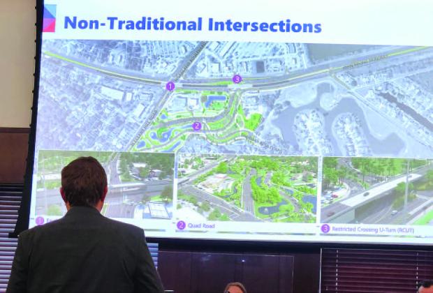 The Florida Department of Transportation’s Steven Buck shows a plan to build a road through The Oaks that would improve traffic flow at John Young Parkway and Pleasant Hill Road. PHOTO/KEN JACKSON