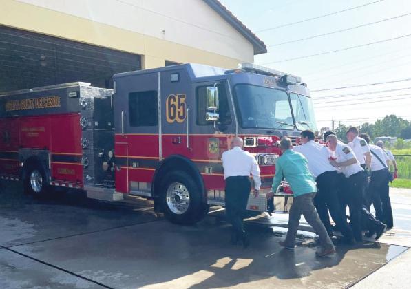 Firefighters of Station 65, along with County Commissioner Brandon Arrington, traditionally wet down and ‘push back’ its newest engine. PHOTO/DONASIA HARRY