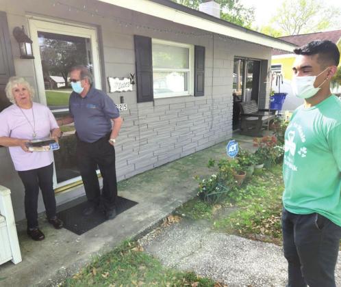 St. Cloud Mayor Nathan Blackwell and Chris Choong from the Osceola Council on Aging deliver a meal, and some conversation, to a St. Cloud resident on March 23. PHOTO/KEN JACKSON