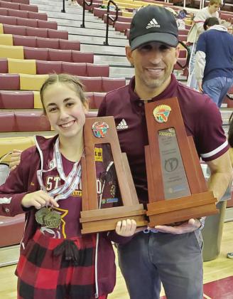 St. Cloud’s Ashley Aun earned double gold in the Region 3A-3 championship, winning both the clean and jerk/ bench and snatch competition at the 101-pound class. Her father and St. Cloud coach Cory Aun displays the Region 3 Team Championship trophy. PHOTO/ST. CLOUD HIGH