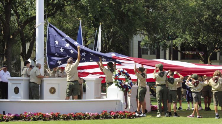 Members of Boy Scout Troop 125 and Cub Scout Troop 125 replace the enormous U.S. flag that flies at Celebration’s Founders’ Park. PHOTO/TERRY LLOYD