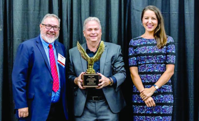 Osceola Heritage Park GM Robb Larson, with Central Florida Central Director of Field Service David Mott and banquet emcee Adrianna Sekula, has been named the Central Florida Council of Boy Scouts’ Golden Eagle Award winner for Osceola County. PHOTO/RTW PHOTOGRAPHY