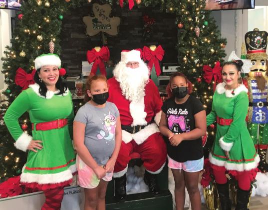 Children visit with Santa Claus at Shamrock Autobody during the toy drive. SUBMITTED PHOTO