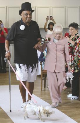 Baby and the escorted mother of the bride, Donna Snyder, come down the aisle. PHOTO/KEN JACKSON