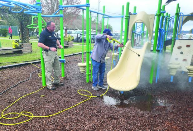 While young volunteers painted and tended to the fresh vegetable garden at Hopkins Park in St. Cloud Monday, adults like Mayor Nathan Blackwell and Police Chief Doug Goerke took to the pressure washer to give the playground a facelift. PHOTOS/KEN JACKSON