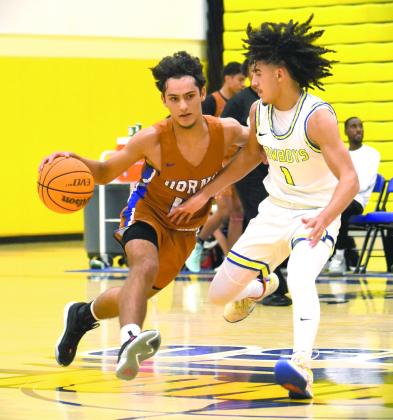 Osceola’s Luke McCrimon defends Harmony’s Ivan Ramos in Tuesday’s season opener. The Longhorns won it, 50-48. PHOTO/KATIE WILLIAMS