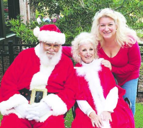 Pete and Pauline Coschignano, dressed up as Mr. and Mrs. Claus, along with their daughter, Osceola Council on Aging, CEO Wendy Ford (right) for a Council on Aging holiday function. (Photo/Osceola Council on Aging)