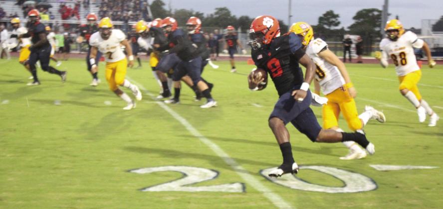 Above, Tohopekaliga’s Churandy Duvall runs for some of his 226 yards in Friday’s 47-6 win over St. Cloud. Left, St. Cloud defenders Malcolm Senono (23) and Terrance Griffin try to stop Tohopekaliga’s Julian Nasco from catching a touchdown pass in Friday’s 47-6 Tiger win. PHOTO/KEN JACKSON
