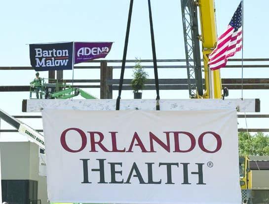 A structural I-beam signed by hospital leaders and medical team members is hoisted into place Thursday to complete the connection to the new section of the hospital. (Photo/Terry Lloyd)