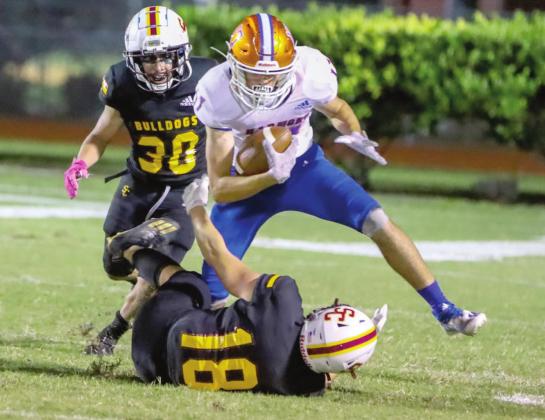 St. Cloud’s Jake Dobrowski (18) and Anthony Morales (30) try to bring down Harmony’s Garrett Rhode in Friday’s 31-30 Soldier City Classic victory. PHOTO / ROB HERBERT