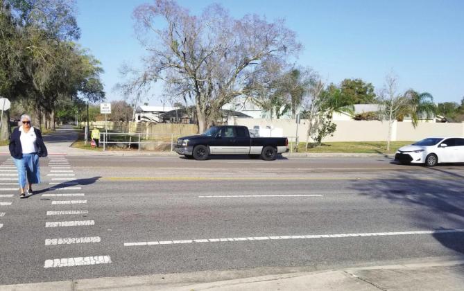 Kissimmee Mayor Olga Gonzalez crosses Thacker Avenue — traffic correctly stopped — during Tuesday morning’s Best Foot Forward enforcement campaign. PHOTO/KEN JACKSON