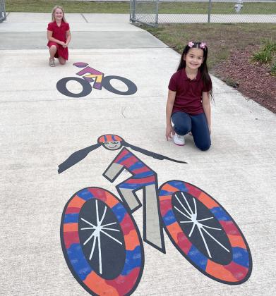 Michigan Avenue Elementary first-grader Olivia Rand and second-grader Kiaraliz Suarez won an FDOT bike-lane art contest, and their design is now displayed on a path outside PHOTO/DEBBIE DANIEL