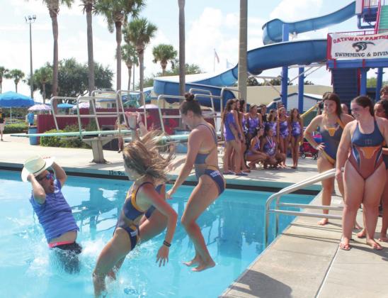 BELOW: Harmony girls’ swimming coach T.J. Walters gets thrown in the Makinson Pool as tradition after the Longhorns again defending its Orange Belt Conference title.