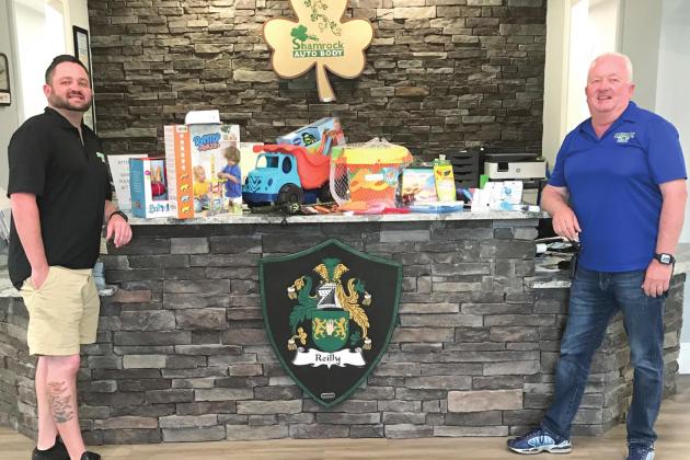 From left, Mike Reilly Jr, and Mike Reilly Sr., will host We Dare to Care’s Drive-Thru Toy Drive at their business Shamrock Autobody to help raise toys and gift cards for less fortunate children in Osceola County. PHOTO/KATHY PIERSON COMMUNICATIONS