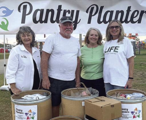 Tammi Madison (left) and Pantry Planters helped collect 859 pounds of food for its newest pantries at the opening night of the Osceola County Fair Feb. 10. Patrons got free fair admission by donating two cans of food. PHOTO/PANTRY PLANTERS