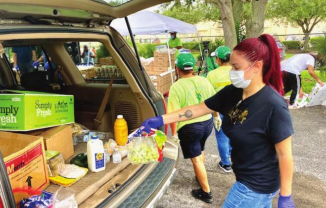 A volunteer loads food into the back of a vehicle. NEWS-GAZETTE PHOTO/BRIAN MCBRIDE