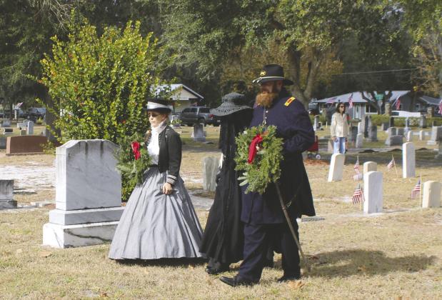 Members of local Civil War family remembrance groups, in period dress, place a wreath on the grave of Union veteran and Medal of Honor recipient Amzi D. Harmon. PHOTO/TERRY LLOYD