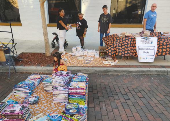 The Florida Education Association and its president Andrew Spar handed out books instead of candy at the Boo on Broadway Halloween event in downtown Kissimmee. (Photo/Ken Jackson)